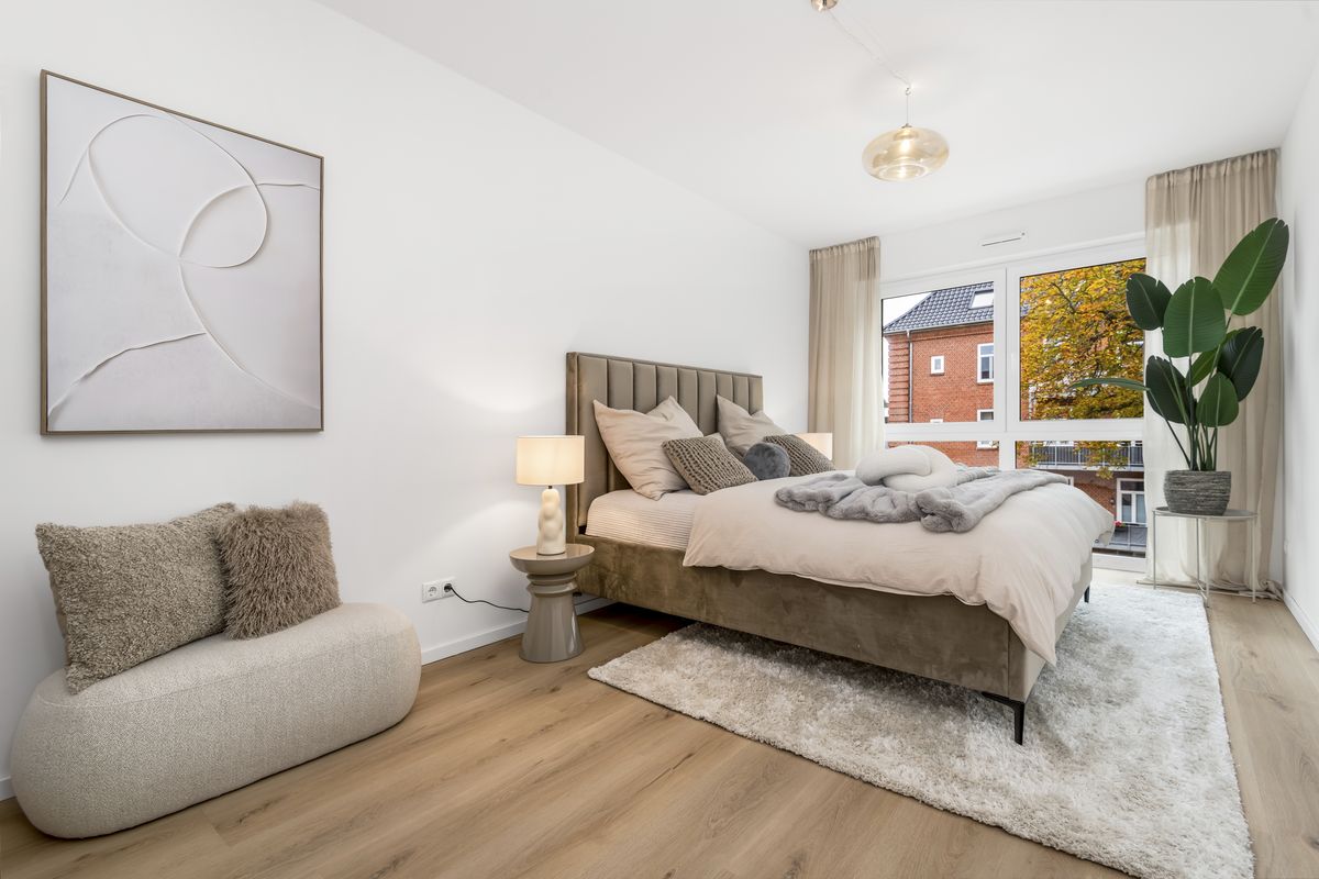 Foto eines eingerichteten Schlafzimmers mit Doppelbett und bodentiefem Fenster
