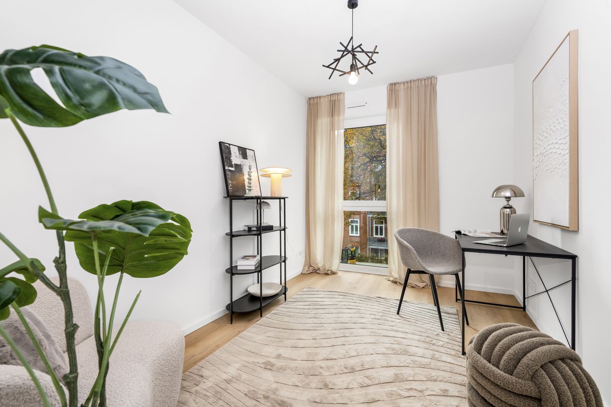 Foto eines Zimmers mit Schreibtisch und bodentiefem Fenster